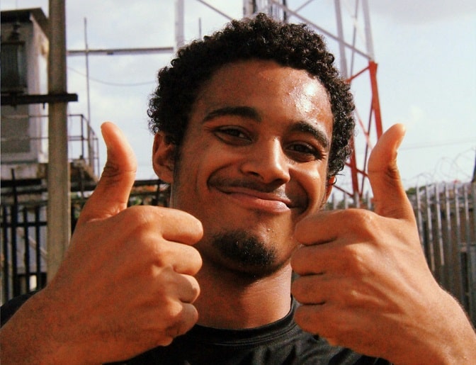 גבר ברזילאי צעיר עושה תנוה של הכל מעולה עם האצבעות