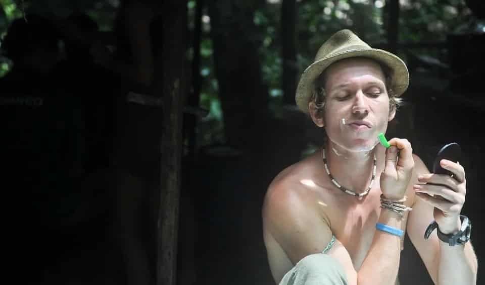 גבר צעיר מתגלח באמצע היער