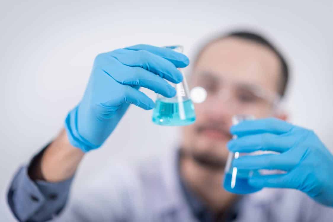 מדען מחזיק שני מבחנות עם נוזלי ערבוב שונים